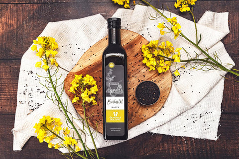 Bio Beikostöl nativ mit Rapsblüten und Rapssamen angerichtet